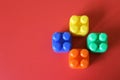 Buildable colored plastic blocks to play, build and organize on a red background as a concept of inclusion, diversity and pluralit Royalty Free Stock Photo