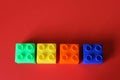 Buildable colored plastic blocks to play, build and organize on a red background as a concept of inclusion, diversity and pluralit Royalty Free Stock Photo