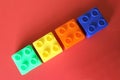 Buildable colored plastic blocks to play, build and organize on a red background as a concept of inclusion, diversity and pluralit Royalty Free Stock Photo