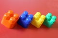 Buildable colored plastic blocks to play, build and organize on a red background as a concept of inclusion, diversity and pluralit Royalty Free Stock Photo