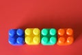 Buildable colored plastic blocks to play, build and organize on a red background as a concept of inclusion, diversity and pluralit Royalty Free Stock Photo