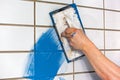 Builder applying colorful blue grouting Royalty Free Stock Photo