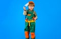 Builder boy in safety helmet and toolbelt with saw. Child in builder uniform with tool belt. Tools for building. Little Royalty Free Stock Photo