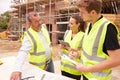 Builder On Building Site Discussing Work With Apprentices Royalty Free Stock Photo