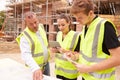 Builder On Building Site Discussing Work With Apprentices Royalty Free Stock Photo