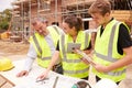 Builder On Building Site Discussing Work With Apprentices Royalty Free Stock Photo