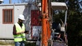 Builder at building site wearing work helmet and reflecting jacket use tablet for test and checking. Royalty Free Stock Photo