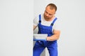 The builder carefully corrects the irregularities of the wall with a trowel. Builder in work clothes against a gray wall. Photo