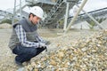 Builder checking pebbles outside construction site Royalty Free Stock Photo