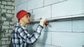 Builder checking straightness of aerated concrete block wall with bubble level Royalty Free Stock Photo