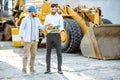 Builder with a sales consultant at the shop with heavy machinery Royalty Free Stock Photo