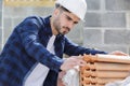 Builder collecting roof tile from stack