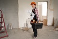 builder on a construction site with a box of tools, drawings and a house plan in his hands Royalty Free Stock Photo