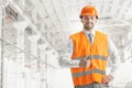 The builder in orange helmet against industrial background