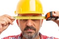 Builder covering eyes with measuring tape