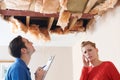 Builder And Customer Discussing Ceiling Repair