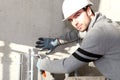 Builder cutting an outdoor pipe Royalty Free Stock Photo