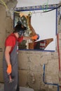 Builder destroying a mirror with a hammer
