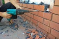 The builder dismantles the brick in the wall with a punch Royalty Free Stock Photo