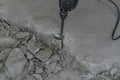 A builder dismantles a perforator drill breaks the concrete floor at a construction site