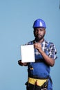 Builder with electronic device against blue background