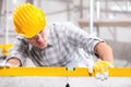 Builder or engineer in a hardhat using a spirit level Royalty Free Stock Photo