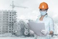 Builder engineer looking at the project on the background of the construction site