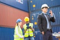 Builder Engineering in hardhat with walkie talkie over group of builders at construction site Royalty Free Stock Photo