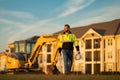 Builder on excavator. Builder worker with excavator. Builder in helmet. Worker in hardhat. Portrait mechanical worker in