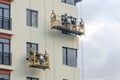 Builder at facade construction work hanging cradles. Royalty Free Stock Photo