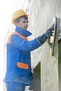 Builder at facade plastering work with putty knife float Royalty Free Stock Photo