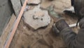 Builder faces the basement of a house with a wild stone. Flat for cladding, tabata on the construction site.