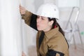 Builder female indoor worker after plastering wall