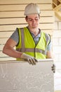 Builder Fitting Insulation Boards Into Roof Of New Home Royalty Free Stock Photo