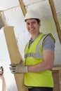 Builder Fitting Insulation Boards Into Roof Of New House Royalty Free Stock Photo