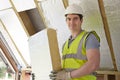 Builder Fitting Insulation Boards Into Roof Of New House Royalty Free Stock Photo