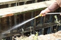 The builder flushes the metal formwork shield with water from the hose