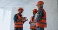Builder gesturing while talking with coworkers