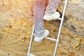 Builder going up the ladder to get out of trench