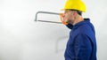 Builder with a hacksaw in his hands,a smiling man with a construction helmet,on a white background.Construction worker. Royalty Free Stock Photo