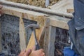 Builder hammering a nail into a piece of wood 4