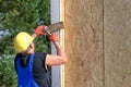 Builder hammering on a wooden wall panel