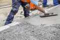 Builder hand leveling concrete with trowel