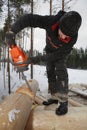 Builder handles timber, cutting a round saddle notch with chains