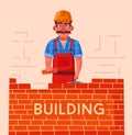 Builder in a hard hat is building a brick wall