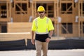 Builder in a hard hat working on a construction project at a site. A builder worker in a helmet near building Royalty Free Stock Photo