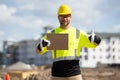 Builder in a hard hat working on a construction project at a site. A builder worker in a helmet near building Royalty Free Stock Photo