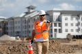 Builder in a hard hat working on a construction project at a site. A builder worker in a helmet near building Royalty Free Stock Photo