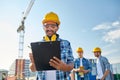 Builder in hardhat with clipboard at construction Royalty Free Stock Photo