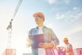 Builder in hardhat with clipboard at construction Royalty Free Stock Photo